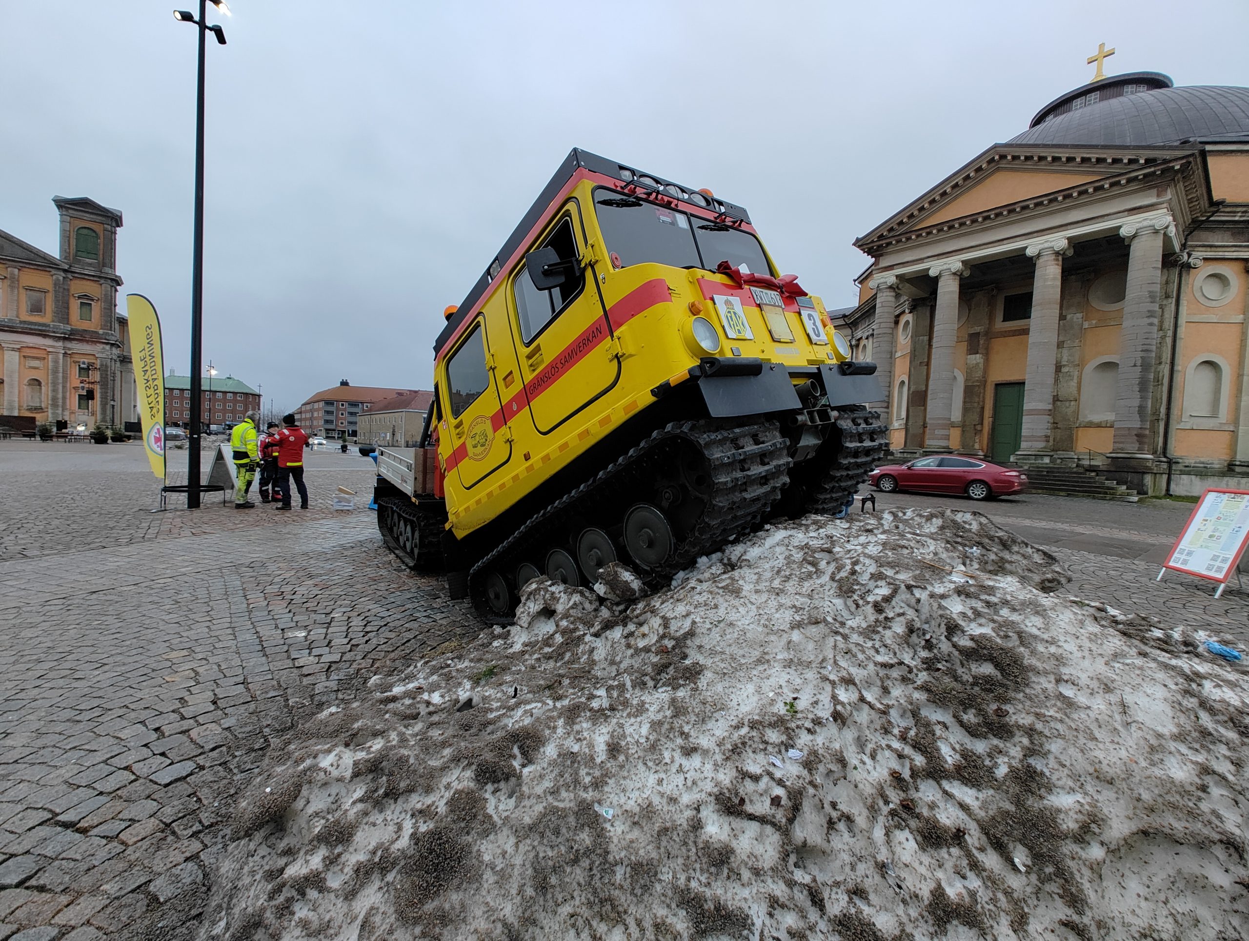 Bandvagn halvvägs upp i snöhög.