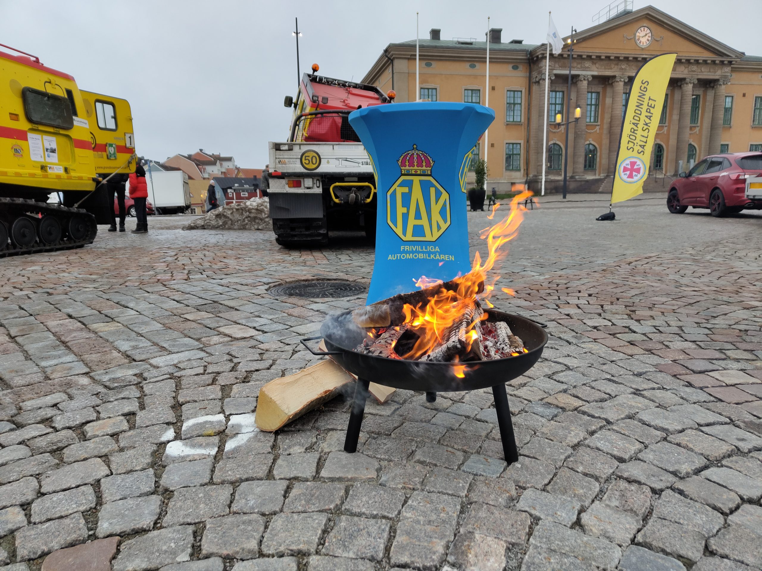 Eldfat med brinnande ved framför FAK's bord.